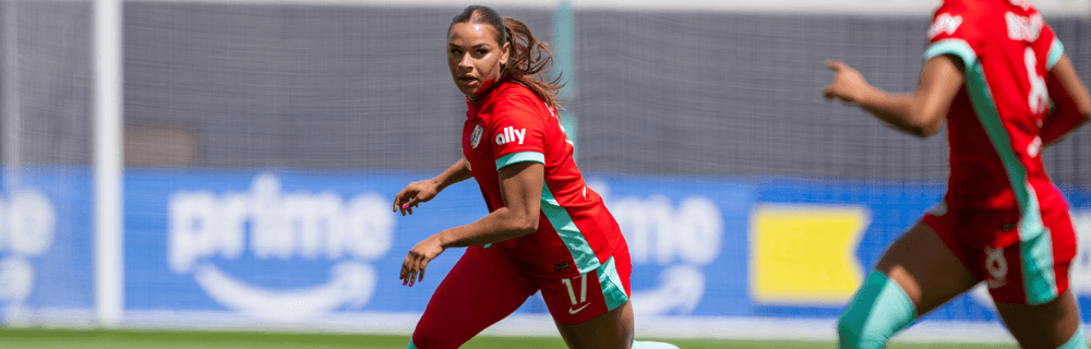 Michelle dribbling the soccer ball with Croix as match preview cover photo.